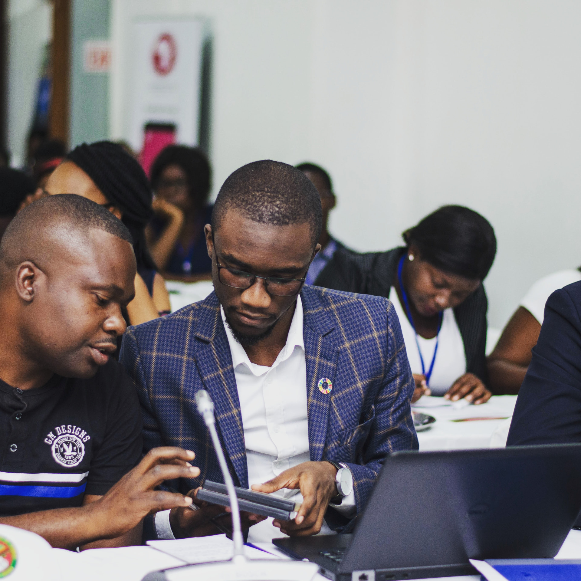 Shuko Musemangezhi reviewing data with colleagues around a tablet